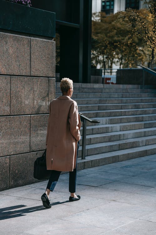 棕色外套在灰色的混凝土楼梯上行走的女人 · 免费素材图片