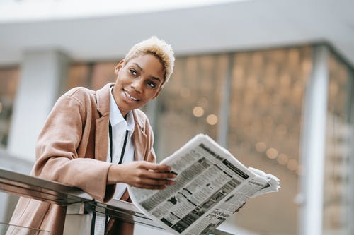 棕色外套读报纸的女人 · 免费素材图片