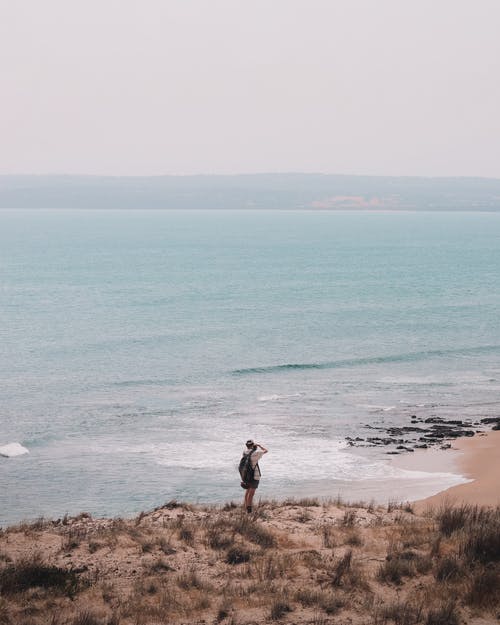 男性旅行者拍照的海景 · 免费素材图片