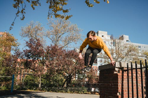 活跃的男性从街上的篱笆跳 · 免费素材图片