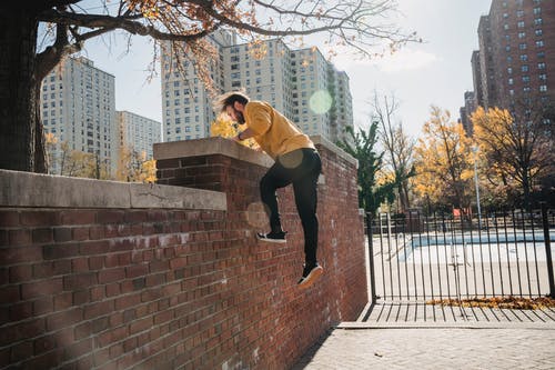 在城市公园的篱笆上跳跃的人 · 免费素材图片