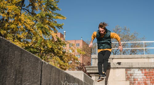 活跃的人跳上屋顶的边缘 · 免费素材图片