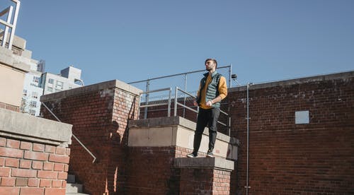 时尚的男人站在砖建筑 · 免费素材图片