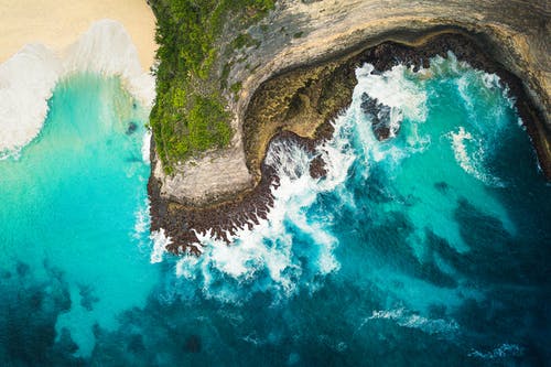 水体旁的棕色岩石地层 · 免费素材图片