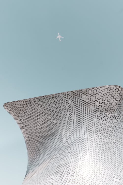 客机飞越建筑物 · 免费素材图片