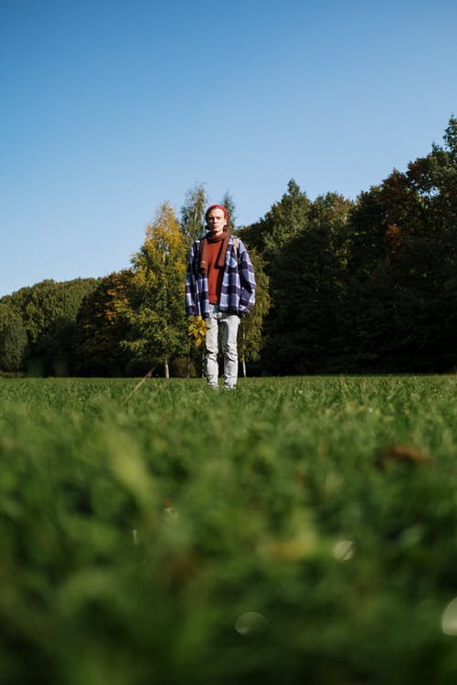 站在绿草地上的黑色和红色外套的男人 · 免费素材图片