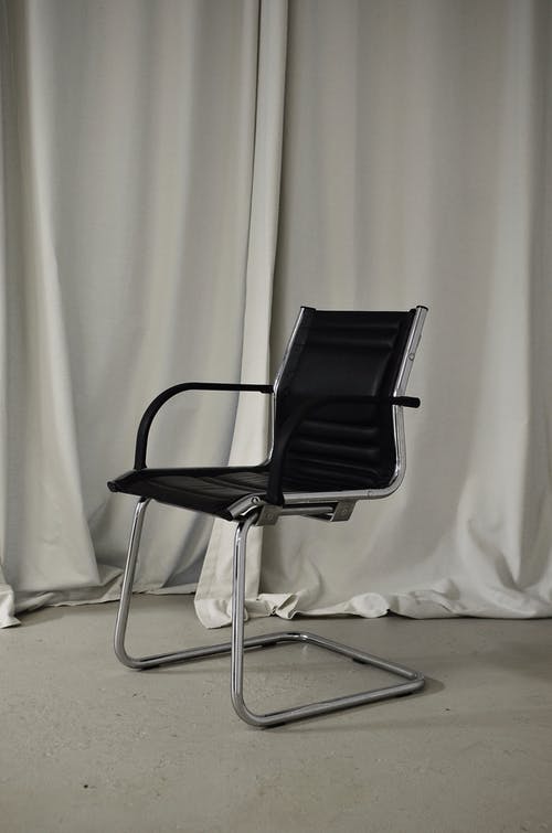 白色窗帘旁边的黑色和银色椅子 · 免费素材图片