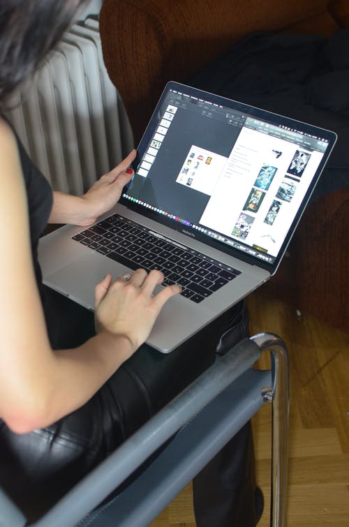 在黑色皮椅上使用macbook Pro的人 · 免费素材图片