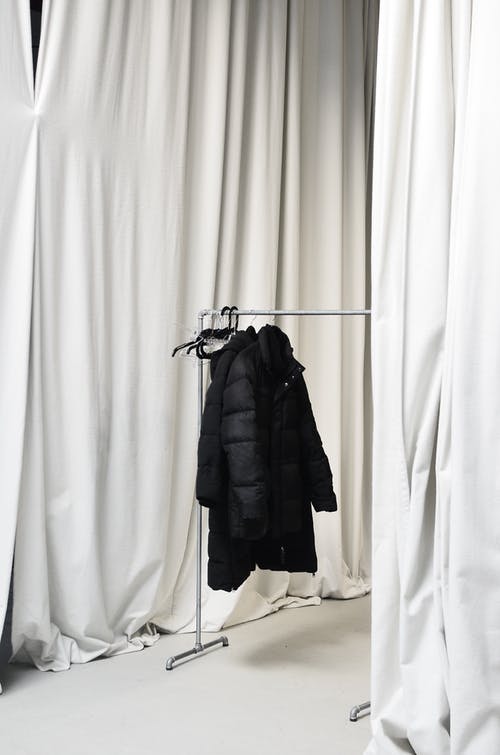 黑色外套挂在黑色衣架上 · 免费素材图片