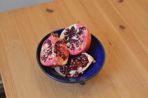 在黑色的圆板上切石榴果 · 免费素材图片