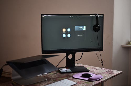 棕色的木桌上的黑色平板电脑显示器 · 免费素材图片