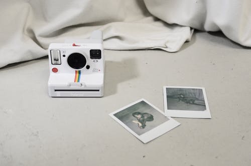 白色和白色纺织上的绿色相机 · 免费素材图片