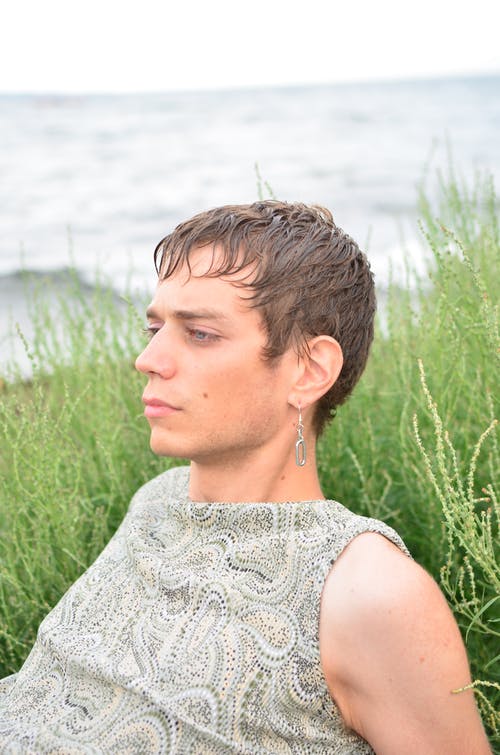 白色花蕾丝无袖衬衫站在绿色的草地上的女人 · 免费素材图片