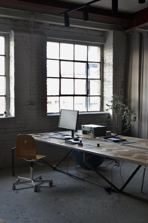 黑色笔记本计算机棕色木制的桌子上 · 免费素材图片