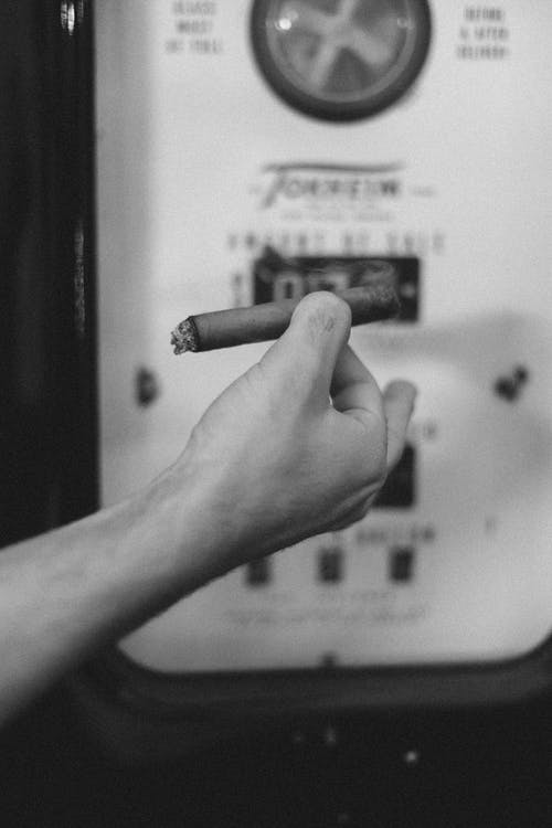 加油站上的匿名家伙吸烟雪茄 · 免费素材图片
