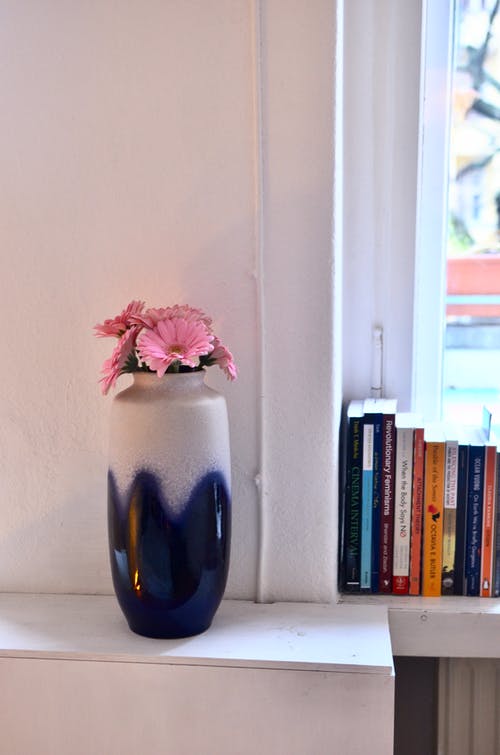 蓝色玻璃花瓶中的粉红和白色花朵 · 免费素材图片