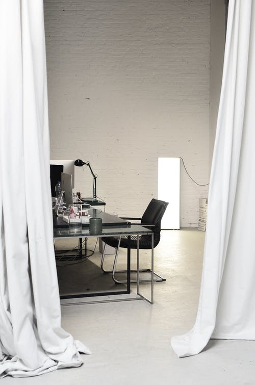 桌子旁边的黑色和灰色椅子 · 免费素材图片