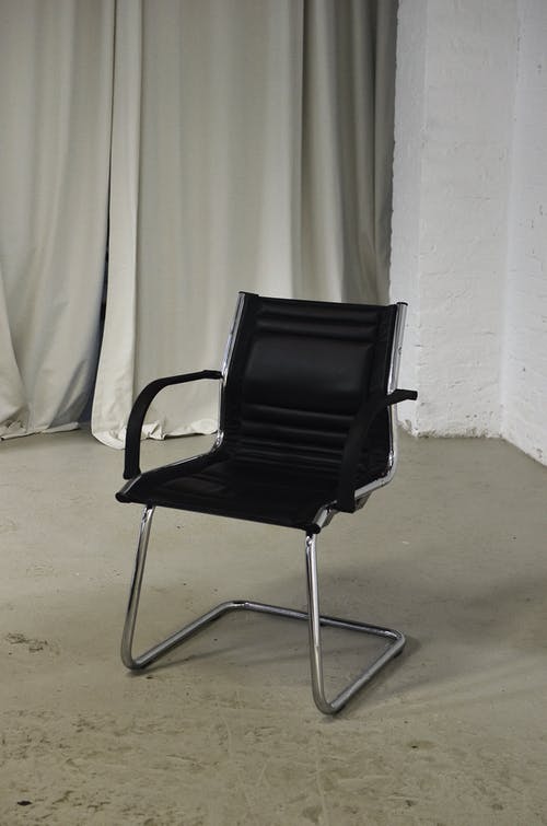 白色窗帘旁边的黑色和银色椅子 · 免费素材图片