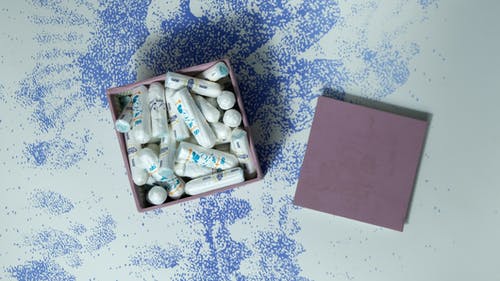 白色和蓝色花卉纺织上的粉红色粘滞便笺 · 免费素材图片