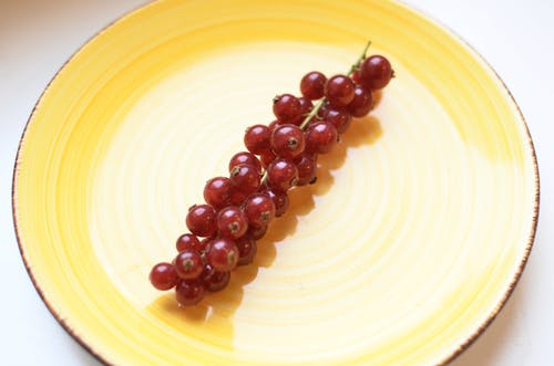 黄色圆形板上的红色圆形水果 · 免费素材图片