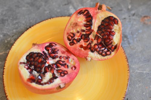 在黄色板上切石榴果 · 免费素材图片