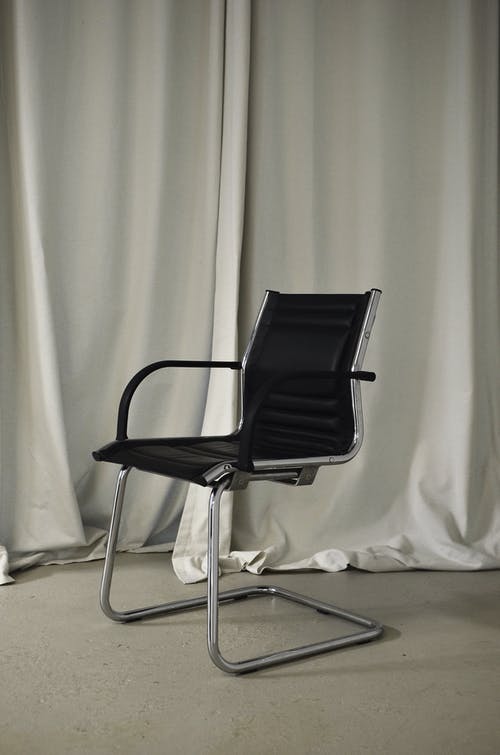 白色纺织品上的黑色和银色椅子 · 免费素材图片