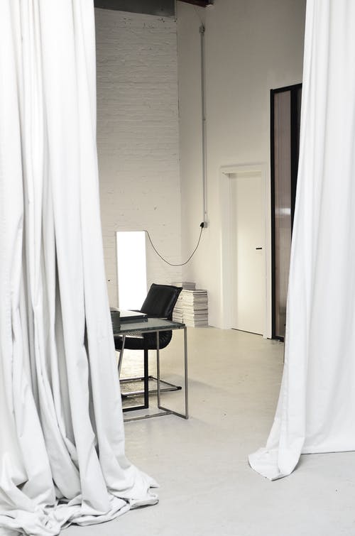 白色窗帘附近的黑色和白色椅子 · 免费素材图片