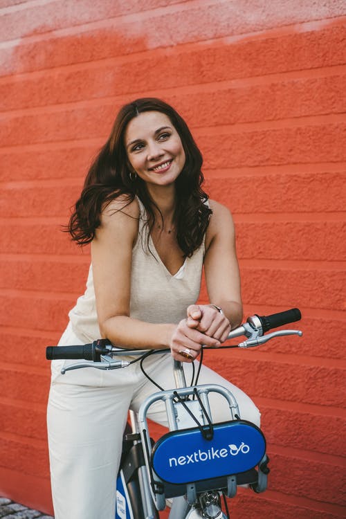 骑自行车的白色背心的女人 · 免费素材图片