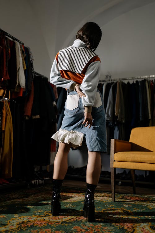 白色和黑色条纹长袖衬衫和灰色裙子站在附近的衣服的女人 · 免费素材图片