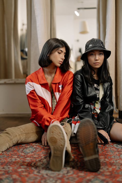 红色和白色外套，坐在棕色的沙发上的女人 · 免费素材图片