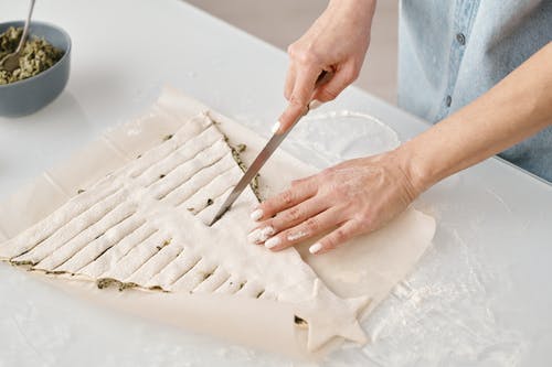 切成薄片的圣诞树形面包的人 · 免费素材图片