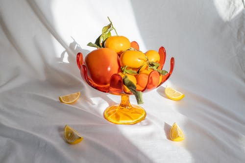 成熟的水果和柿子在不寻常的玻璃花瓶 · 免费素材图片