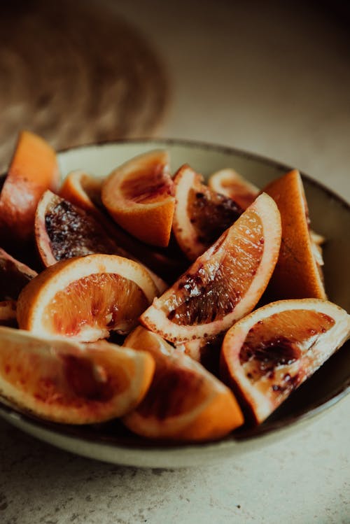 在白色陶瓷板上切橙色的水果 · 免费素材图片