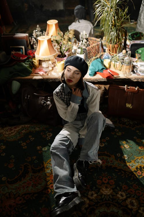 坐在绿色和黑色的花床上的灰色裤子的男孩 · 免费素材图片