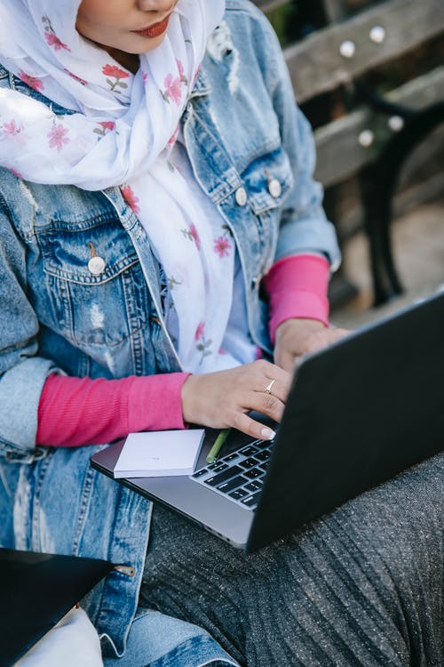 使用macbook的蓝色牛仔夹克的女人 · 免费素材图片