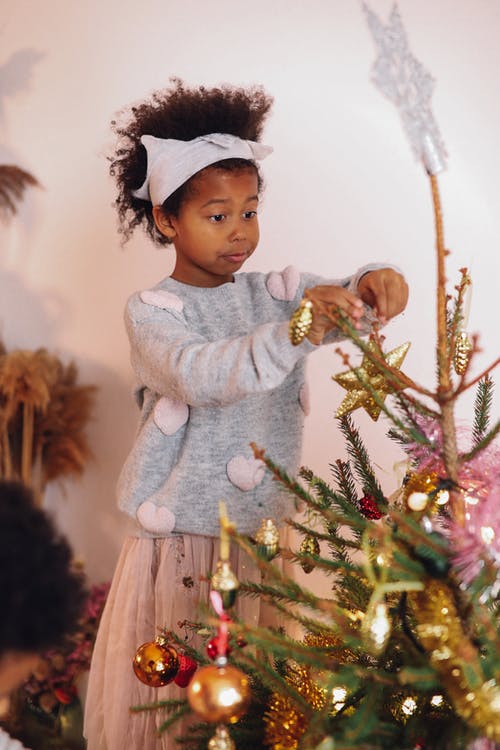 装饰圣诞树的灰色毛衣的女孩 · 免费素材图片