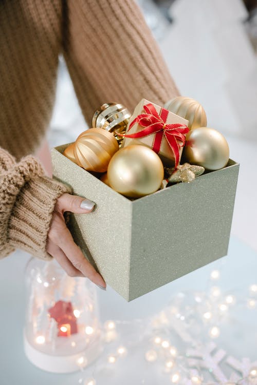 持有绿色和金色的小玩意的人 · 免费素材图片