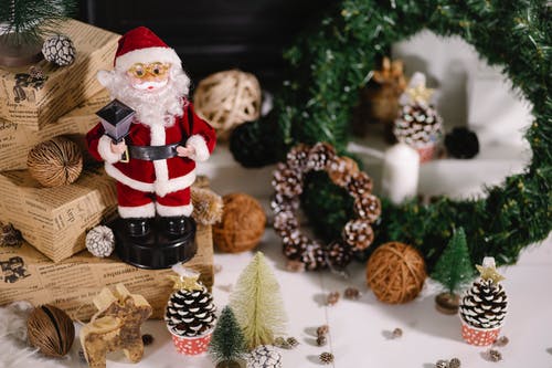 棕色和白色松果旁边的圣诞老人公仔 · 免费素材图片