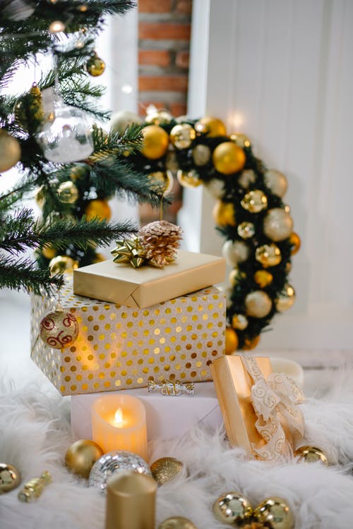 绿色圣诞树旁边的棕色和白色礼品盒 · 免费素材图片