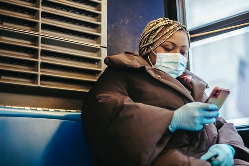 坐在蓝色的沙发上的棕色外套的男人 · 免费素材图片