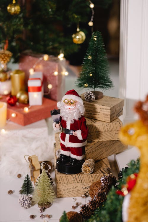棕色木制礼品盒旁边的圣诞老人公仔 · 免费素材图片