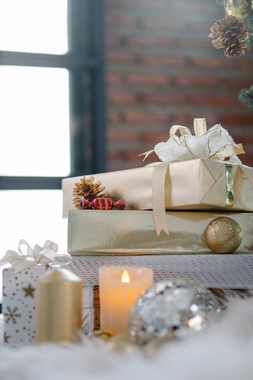 白色礼品盒用金丝带棕色木制的桌子上 · 免费素材图片