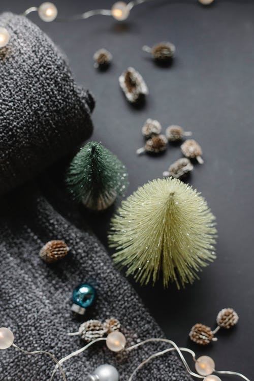 白色和绿色圆形装饰旁边的黑色和白色皮手套 · 免费素材图片