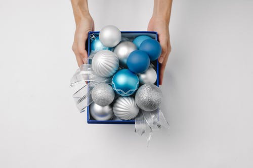 拿着蓝色和灰色气球的人 · 免费素材图片