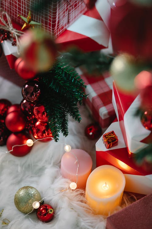 绿色圣诞树的小玩意和点燃的蜡烛 · 免费素材图片