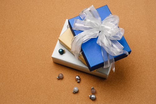 蓝色和白色的盒子，用棕色的桌子上的白丝带 · 免费素材图片