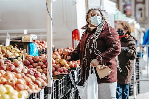 拿着白色塑料袋的棕色夹克的女人 · 免费素材图片