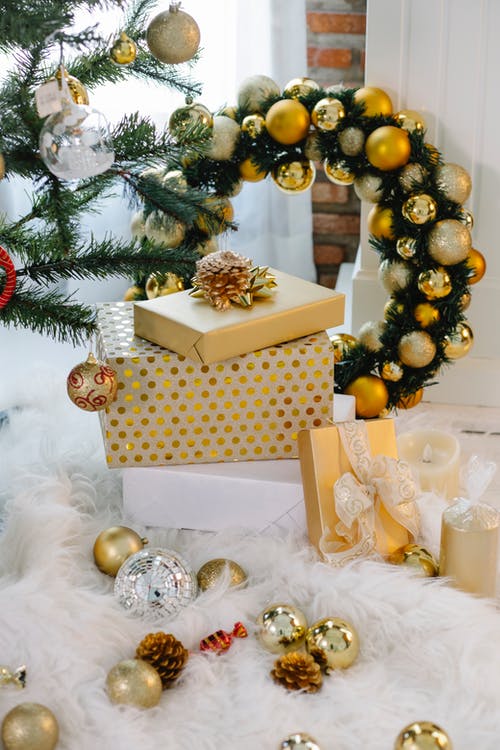金色和白色礼品盒上的金色和银色小玩意 · 免费素材图片