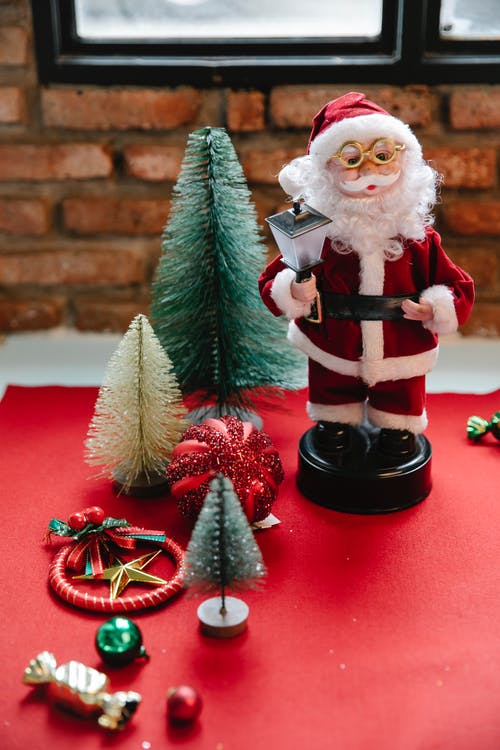 圣诞老人雕像旁边绿色的松树 · 免费素材图片