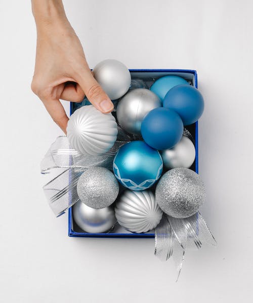 拿着蓝色和灰色气球的人 · 免费素材图片